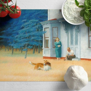Puede incluir: Una pintura de una casa blanca con una pareja de pie afuera. Un perro corre en la hierba frente a la casa. La pintura está en una tabla de cortar con tomates, albahaca y ajo.
