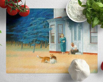 May include: A painting of a white house with a couple standing outside. A dog is running in the grass in front of the house. The painting is on a cutting board with tomatoes, basil, and garlic.