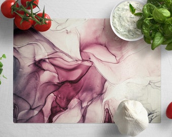 Peut inclure: Une planche à découper de couleur abstraite violette et blanche avec une gousse d'ail blanche, des tomates et un bol de sauce sur une surface blanche.