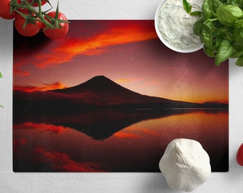 Peut inclure: Un coucher de soleil rouge et orange au-dessus d'une montagne reflétée dans un lac calme. La montagne est silhouettée contre le ciel.