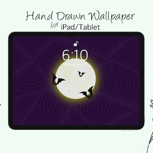 May include: A tablet displays a hand-drawn Halloween-themed wallpaper. The design features a full moon with bats silhouetted against it, set against a swirling purple background. The time is 6:10 AM, Saturday, June 23.
