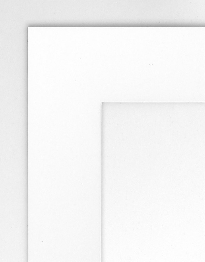 May include: A white mat with a white border around the edge. The mat has a smaller white rectangle cut out in the center.