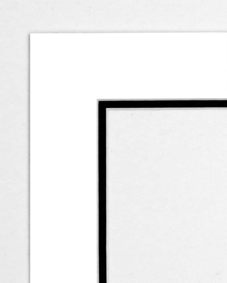 May include: A white mat with a black border around the edge.