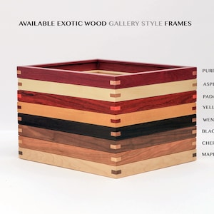 May include: A stack of eight different wood picture frames, each with a different wood type. The wood types are: Purpleheart, Aspen, Padauk, Yellowheart, Wenge, Black Walnut, Cherry, and Maple.