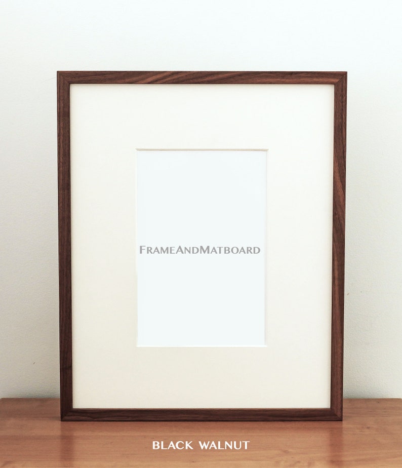 May include: A black walnut wood picture frame with a white mat and a white background. The frame is 11x14 inches.