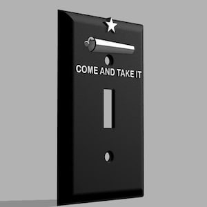 Puede incluir: Cubierta de interruptor de luz negra con el texto "COME AND TAKE IT" en blanco. Cuenta con un interruptor basculante plateado, una estrella y una abertura rectangular para el interruptor. El diseño es simple y moderno.