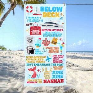 May include: A light blue beach towel with nautical-themed graphics and text. The towel features a yacht, life preserver, and various phrases like "Below Deck" and "Cocktails are the Answer." The name "Hannah" is also displayed.