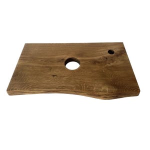 Può includere: Un piano di lavoro in legno rustico con un taglio circolare, perfetto per un lavandino o un altro apparecchio idraulico. Il legno ha un colore marrone naturale e una superficie leggermente irregolare.