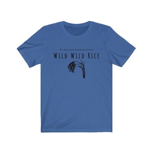Puede incluir: Una camiseta azul con el texto "In the canoe knocking bizania WILD WILD RICE" y una silueta negra de un tallo de arroz.