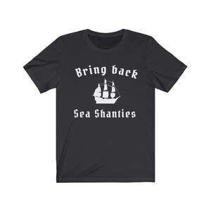 Może przedstawiać: Czarny T-shirt z białym napisem "Bring back Sea Shanties" i białą sylwetką żaglowca.