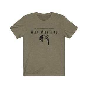 Puede incluir: Una camiseta verde con el texto "In the canoe knocking, sis, and WILD WILD RICE" y una silueta negra de un tallo de arroz.