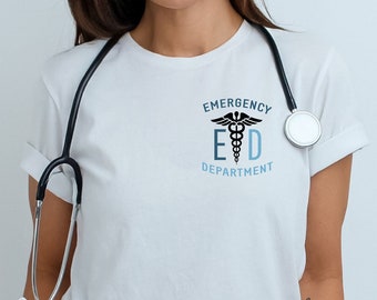 May include: A white t-shirt with a blue and black graphic of a medical caduceus and the text "Emergency E D Department". A black stethoscope is draped around the neck of the shirt.