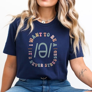 May include: A navy blue t-shirt with a colorful graphic that says "I want to be a stressed / it's never" in a circle.