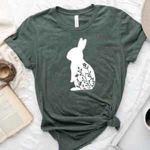 May include: A green t-shirt with a white silhouette of a rabbit with flowers inside the silhouette.