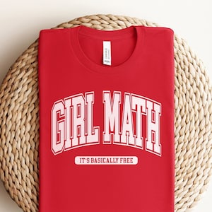 Op de afbeelding: Rood T-shirt met witte tekst die "Girl Math It's Basically Free" zegt.