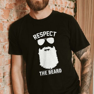 May include: A black t-shirt with a white graphic of a bearded man wearing sunglasses and the text "Respect the Beard".