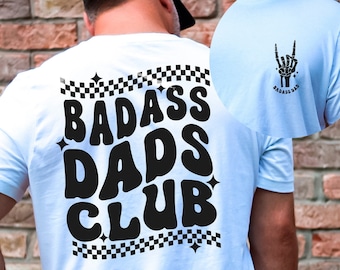 May include: White t-shirt with black text that reads "Badass Dads Club" in a retro font. The text is surrounded by a checkered pattern.