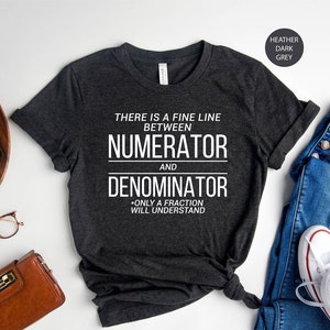 May include: A heather dark grey t-shirt with the text "THERE IS A FINE LINE BETWEEN NUMERATOR AND DENOMINATOR - ONLY A FRACTION WILL UNDERSTAND".