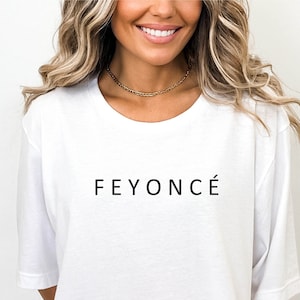 Pu&ograve; includere: Maglietta bianca oversize con la scritta "FEYONC&Eacute;" stampata in nero sul davanti.