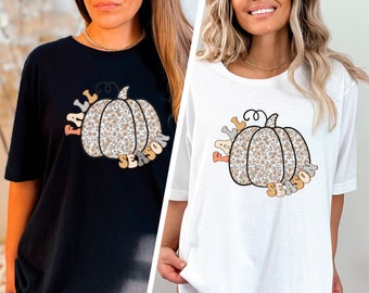 Puede incluir: Dos camisetas blancas con un gráfico de calabaza negro y marrón y el texto "Fall Season".