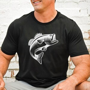 May include: A black t-shirt featuring a white graphic of a bass fish leaping out of the water.