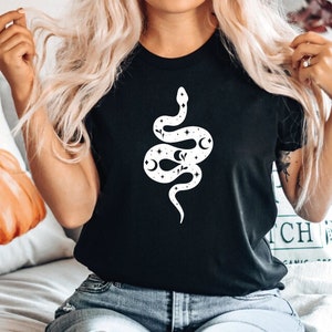 May include: A black t-shirt with a white graphic of a snake with stars and moons on it.