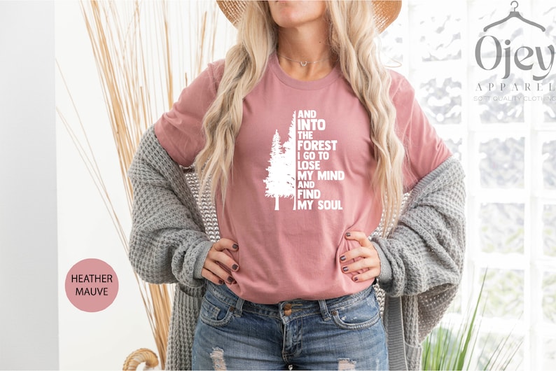 May include: A heather mauve t-shirt with a white graphic of a tree and the text "And into the forest I go to lose my mind and find my soul".