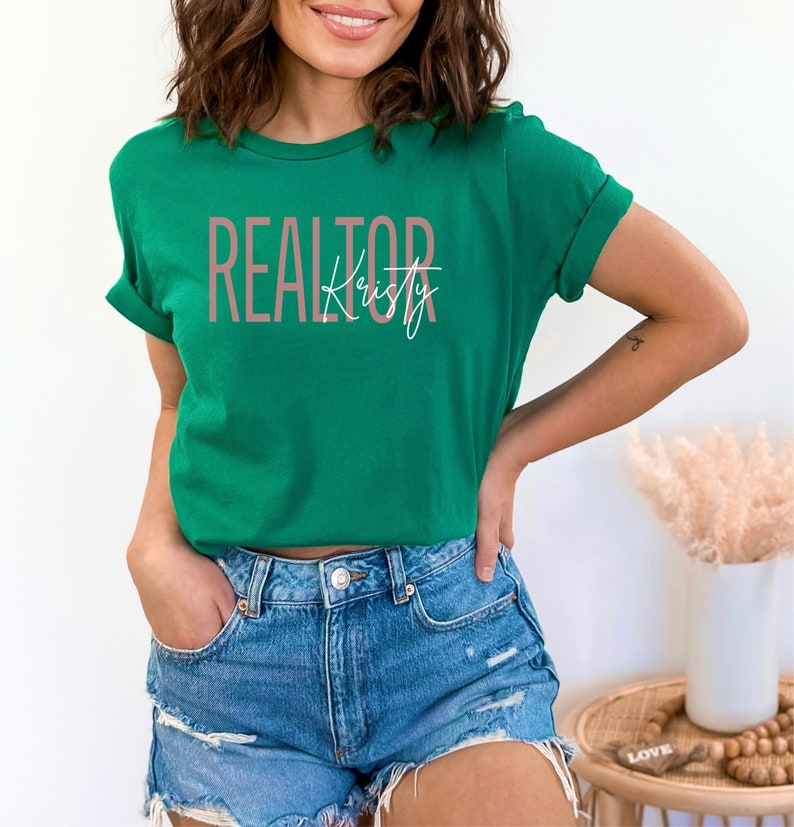 Peut inclure: Un t-shirt vert avec le texte "REALTOR" en rose et le nom "Kristy" en &eacute;criture blanche.