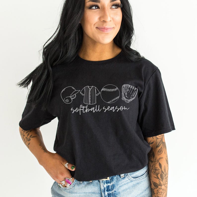 May include: Black t-shirt with a white graphic of softball equipment and the text "softball season".
