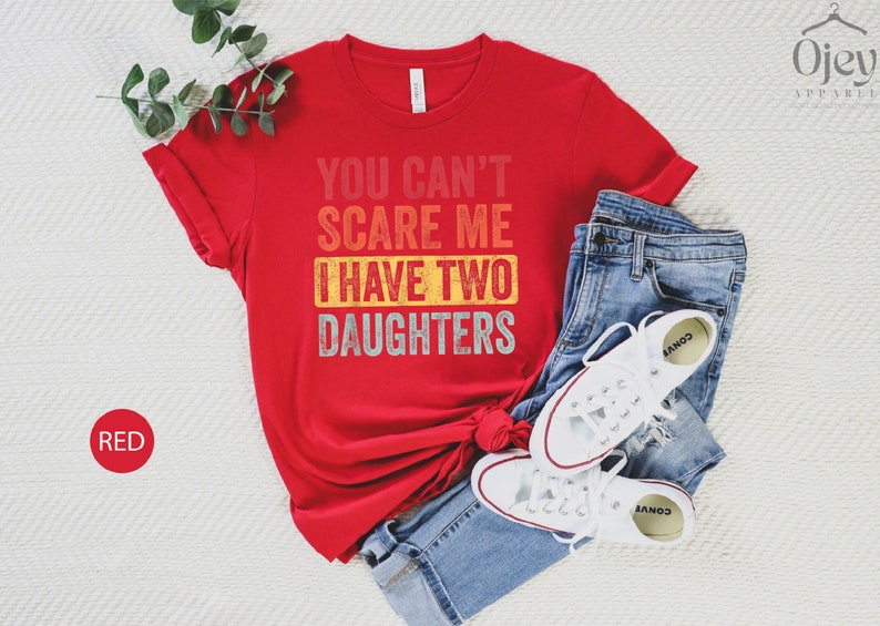 Puede incluir: Camiseta roja con un gr&aacute;fico vintage desgastado que dice "You Can't Scare Me I Have Two Daughters".