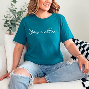 May include: A teal blue t-shirt with the text "You matter." in white script.