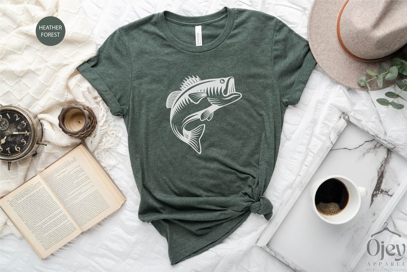 May include: A heather forest green t-shirt with a white graphic of a bass fish jumping out of the water.