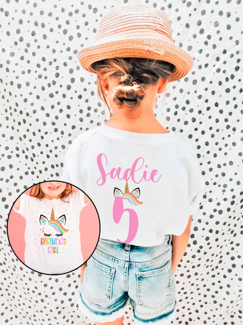 May include: White t-shirt with a pink unicorn and the number 5 on the back. The front of the shirt has a unicorn with a rainbow mane and the text "Birthday Girl".