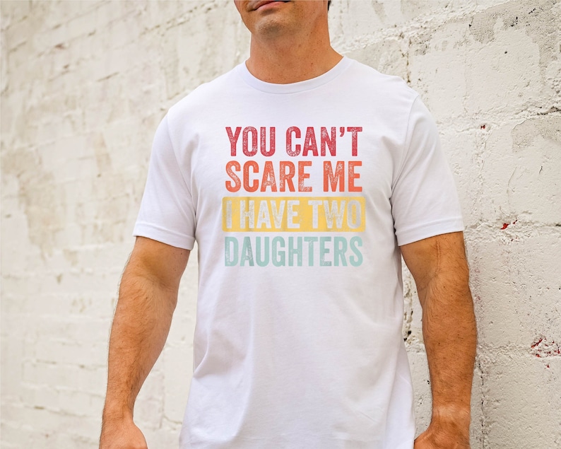 Puede incluir: Camiseta blanca con un gr&aacute;fico de estilo vintage que dice "You can't scare me I have two daughters".