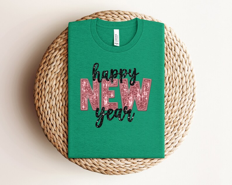 May include: Green t-shirt with the text "happy new year" in pink glitter letters with black outlines.