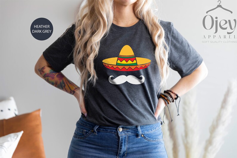 May include: A heather dark grey t-shirt with a graphic of a white mustache and a yellow, red, and green sombrero.