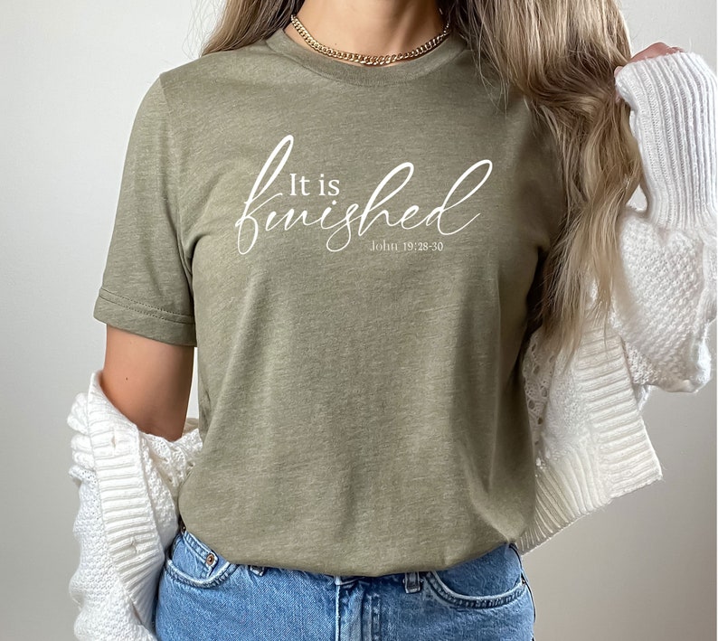 May include: A green t-shirt with the text "It is finished" in white cursive lettering and the scripture reference "John 19:28-30" underneath.