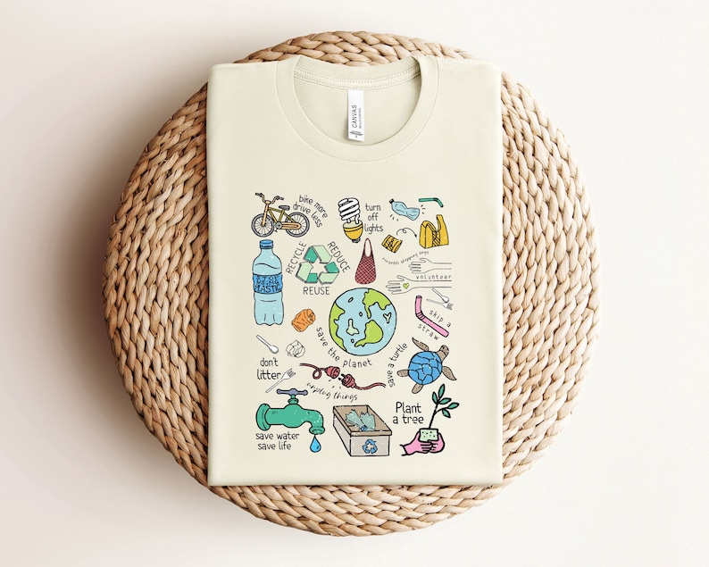 May include: A beige t-shirt with a colorful illustration of various ways to help the environment. The illustration includes a bicycle, a lightbulb, a water bottle, a recycling symbol, a globe, a turtle, a faucet, a tree, and the words "don't litter", "save the planet", "save water save life", "plant a tree", "recycle reduce reuse", "turn off lights", "skip a straw", "bike more drive less", "reusing things".