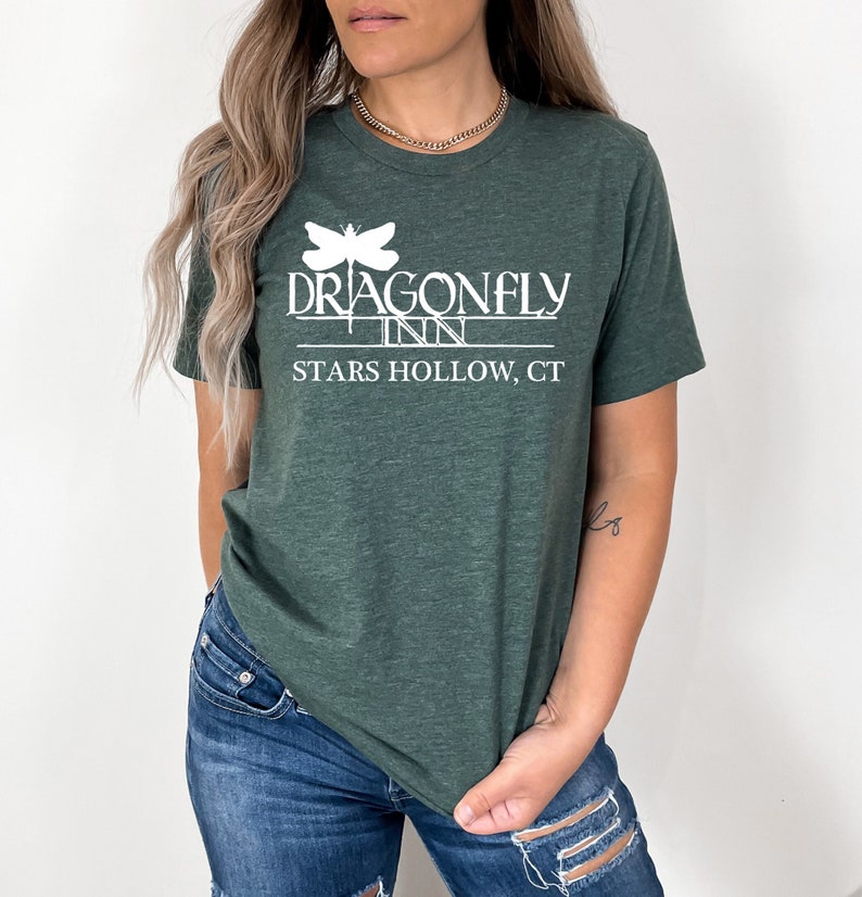 May include: A green t-shirt with a white graphic of a dragonfly and the text "Dragonfly Inn Stars Hollow, CT".