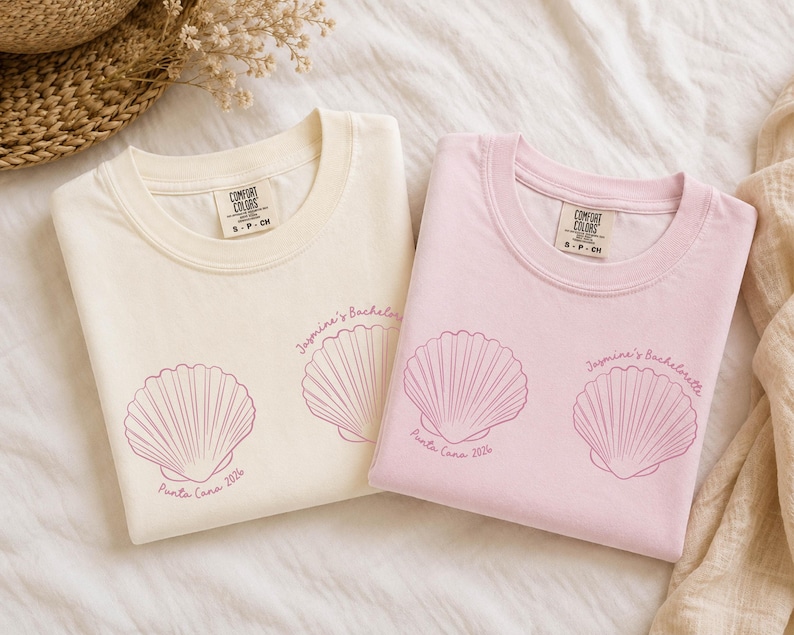 May include: Two crew neck t-shirts, one cream and one light pink, each featuring a dark pink line art graphic of two seashells. The text "Jasmine's Bachelorette" and "Punta Cana 2024" is printed in a cursive font near the seashell illustrations.