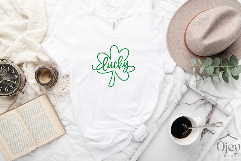 May include: White t-shirt with a green shamrock and the word "lucky" written in cursive.