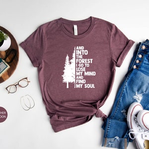 May include: Heather maroon t-shirt with a white graphic of a tree and the text "And into the forest I go to lose my mind and find my soul".