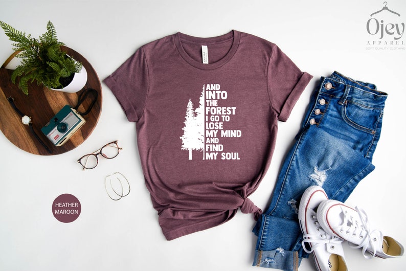 May include: Heather maroon t-shirt with a white graphic of a tree and the text "And into the forest I go to lose my mind and find my soul".