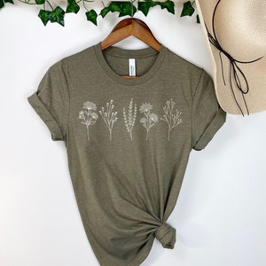 May include: A green t-shirt with a white floral design. The shirt is made of a soft, comfortable material and has a relaxed fit.