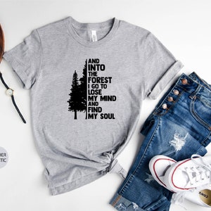 May include: A heather grey t-shirt with a black silhouette of a pine tree and the text "And into the forest I go to lose my mind and find my soul".