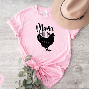 May include: Pink t-shirt with a black silhouette of a chicken and the text "Mama Hen".