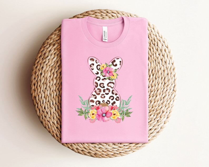 May include: Pink t-shirt with a floral design featuring a leopard print Easter bunny.