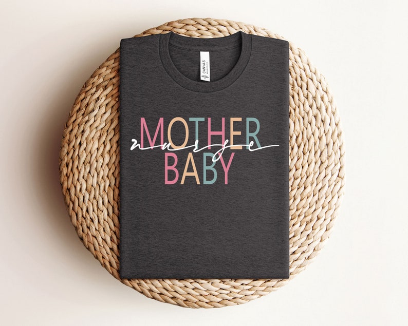 Puede incluir: Una camiseta gris oscuro con el texto "Madre de un beb&eacute;" en letras de colores. El texto est&aacute; en un estilo moderno y manuscrito.