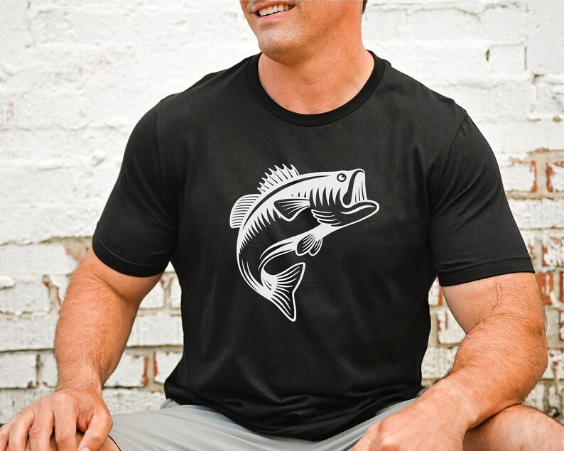 May include: A black t-shirt featuring a white graphic of a bass fish leaping out of the water.