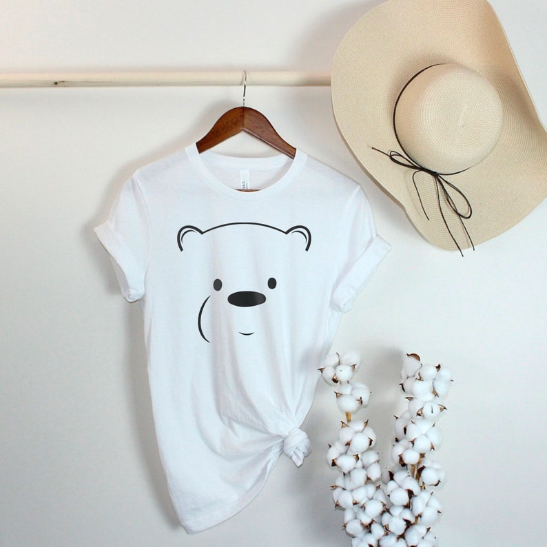 May include: White t-shirt with a black outline of a polar bear face.